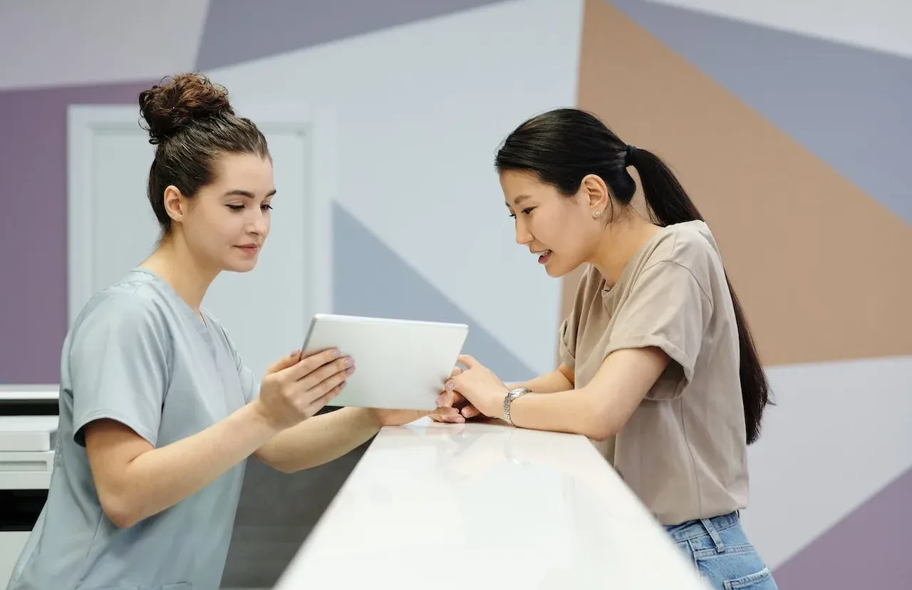 Attendant showing tablet to patient